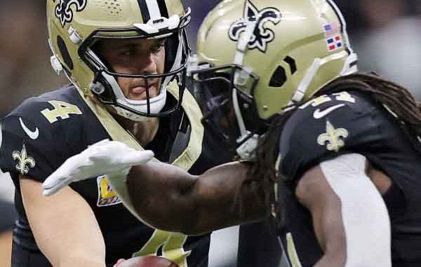 Derek Carr handing the ball off to Alvin Kamara of the New Orleans Saints