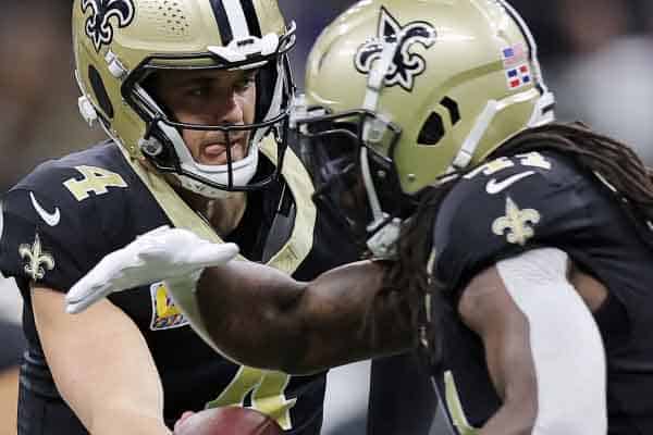 Derek Carr handing the ball off to Alvin Kamara of the New Orleans Saints