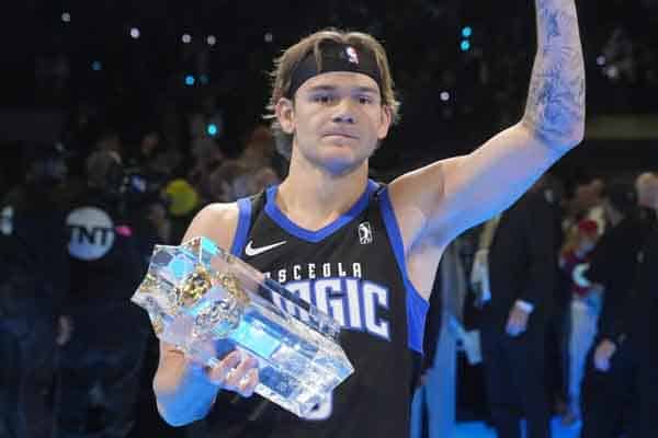 Mac McClung holding a trophy and waving to the crowd